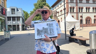 Stadtführer Michael Geib zeigt alte Fotos. Er weiß viel über die Vergangenheit in Kaiserslautern.