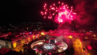 In roten Lichtern ist das Feuerwerk des Schlabbeflickerfestivals über den Dächern von Pirmasens zu sehen. 