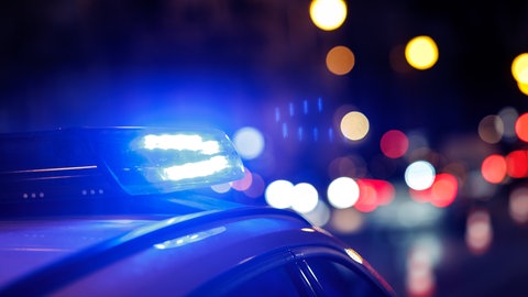 Ein Einsatzfahrzeug der Polizei mit eingeschaltetem Blaulicht bei Nacht. In Kaiserslautern gab es versuchte Raubüberfälle.
