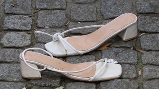 Schuhe auf der Straße. Eine Frau hat sie mit Besteck in Kaiserslautern aus dem Fenster geworfen.