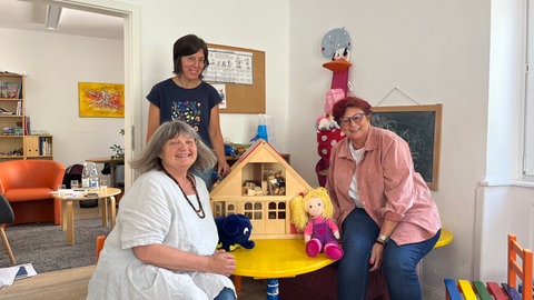 Zum Beratungsteam des Kinderschutzbund Kaiserslautern zählt (v.l.) Dipl.-Psychologin Karin Günther-Wunn, Dipl.-Sozialpädagogin Christina Neuhaus sowie die Leiterin, Dipl.-Psychologin Bärbel Michalik. Sie helfen Familien in Konfliktsituationen, zum Beispiel bei einer Trennung oder Scheidung im Streit um die Kinder. (Drei Frauen sitzen lachend in einem Raum mit Spielsachen.)