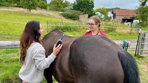 Johanna genießt es, bei Therapiepferd Armani auf dem Kühbörncheshof bei Kaiserslautern sein. Hier erzählt sie mit Therapeutin Eva-Maria Barthel (links). 