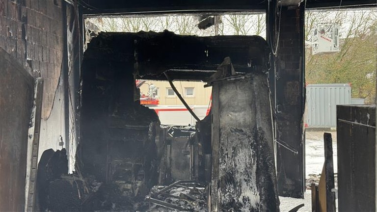 Ausgebranntes Fahrzeug: Nach Angaben der Feuerwehr ist das Feuer in einer Halle ausgebrochen, in der Rettungsfahrzeuge abgestellt sind.
