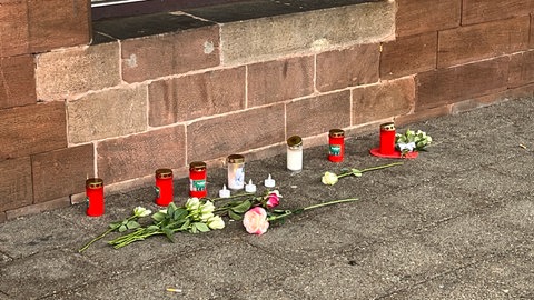 Am Bahnhof Landstuhl im Kreis Kaiserslautern werden zum Gedenken Blumen und Kerzen abgelegt.
