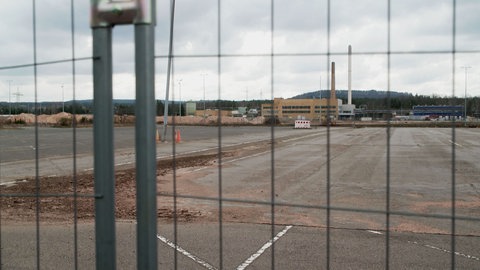 Blick durch einen Bauzaun auf die stillliegende Baustelle der ACC-Batteriefabrick in Kaiserslautern