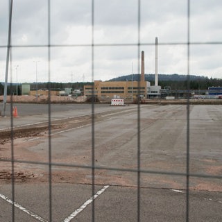 Blick durch einen Bauzaun auf die stillliegende Baustelle der ACC-Batteriefabrick in Kaiserslautern