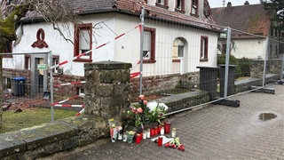 Blumen und Kerzen vor dem Haus in Hermersberg, in dem zwei Menschen bei einem Brand gestorben waren