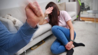 Ein Mann erhebt eine Faust gegen eine Frau - Opfer häuslicher Gewalt in der Westpfalz