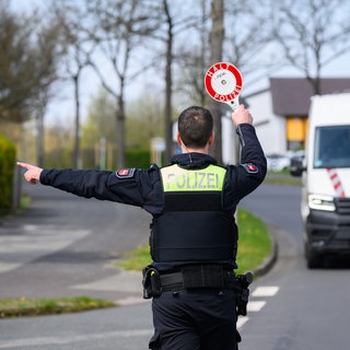 Ein Polizist winkt den Fahrer eines Transporters nach einem Geschwindigkeitsvergehen aus dem Verkehr.