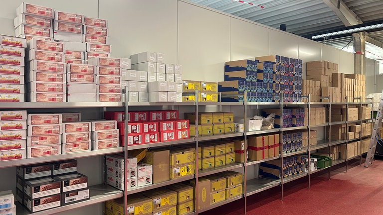 Verpackte Nahrungsmittel, wie Tee und Konfitüre stehen im Warenlager.