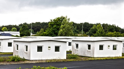 Häuschen für Flüchtlinge in Zweibrücken werden abgebaut - mehrere weiße Häuschen stehen auf einem Gelände