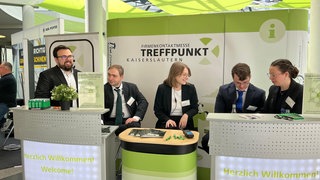 Studierende der RPTU haben die Jobmesse Treffpunkt organisiert, zu Ihnen zählen Sina Gebhardt (r.) und Joshua Cooley (l.). (Menschen stehen an einem Messestand