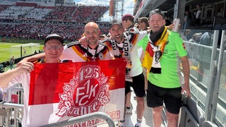 Vier Männer aus Dahn halten FCK-Fahne im Stadion beim WM Spiel Deutschland-Elfenbeinküste.