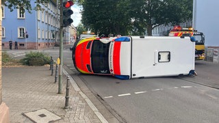 Ein Rettungswagen liegt an einer Kreuzung in Kaiserslautern auf der Seite