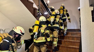 Training für einen internationalen Feuerwehr-Wettkampf an der Skiflugschanze in Oberstdorf: die Feuerwehr aus Steinbach am Donnersberg läuft in Atemschutzkleidung die Treppen der Kreisverwaltung Kirchheimbolanden hoch. 