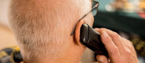 Ein Mann telefoniert. Immer wieder fallen Menschen auf Telefonbetrüger herein. Die Polizei Koblenz will jetzt in einer Veranstaltung darüber informieren, wie man sich schützen kann.