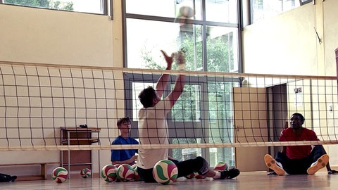Die Sitzvolleyballer Heiko Wiesenthal und Francis Tonleu spielen Sitzvolleyball. Sie üben für die Paralympics in Paris.