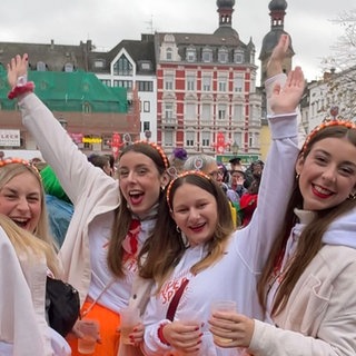 Vier junge Frauen strahlen beim Karnevalsauftakt in Koblenz am 11. November 2024 in die Kamera. 