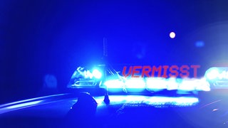 Streifenwagen der Polizei bei Nacht, mit der Blaulicht Aufschrift: Vermisst (Symbolbild)