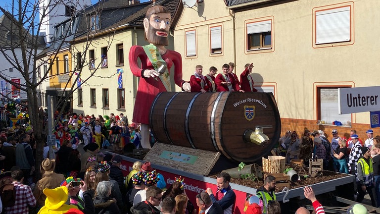 Der Umzug in HeimbachWeis zieht durch den Ort, viele Karnevalisten feiern bunt gekleidet.