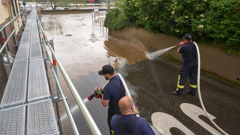 Feuerwehrleute reinigen in Koblenz die Straßen vom Schlamm, den das Hochwasser zurückgelassen hat.