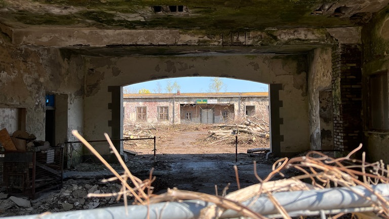 Die baufälligen Gebäude der ehemaligen Fritsch-Kaserne in Koblenz wurden mit einem Bauzaun abgesperrt. In der Ferne ist das frühere Unteroffiziersheim erkennbar. 