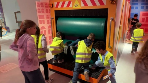 Bei der Ausstellung "Müllmonster-Alarm" können Kinder in dem nachgebauten Müllauto in die Presse springen.