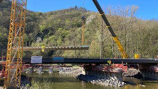 Bei Marienthal an der Ahr sind zwei neue Brücken per Kran auf ihre Pfeiler gesetzt worden. Über diese Brücken soll künftig der Ahrtal-Radweg führen. Die alten Bauwerke waren bei der Flutkatastrophe 2021 zerstört worden.