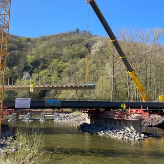 Bei Marienthal an der Ahr sind zwei neue Brücken per Kran auf ihre Pfeiler gesetzt worden. Über diese Brücken soll künftig der Ahrtal-Radweg führen. Die alten Bauwerke waren bei der Flutkatastrophe 2021 zerstört worden.
