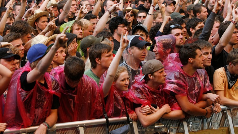 Junge Menschen feiern 2010 im Regen den Abschluss von Rock am Ring. 