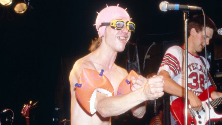Ausgeflippter und fast nackter Fan mit Badekappe 1987 auf der Bühne bei Rock am Ring auf dem Nürburgring.