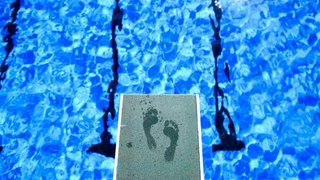 Symbolbild: Fußabdrücke eines Badegastes sind auf dem Ein-Meter-Brett im Freibad zu sehen.
