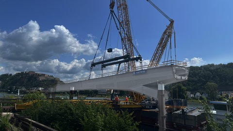 Das erste von drei großen Stahlelementen für die neue Pfaffendorfer Brücke wird eingebaut.