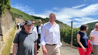 Ministerpräsident Schweitzer wandert mit Kabinettsmitgliedern und Kommunalpolitikern auf dem Rotweinwanderweg im Ahrtal.