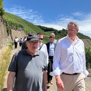Ministerpräsident Schweitzer wandert mit Kabinettsmitgliedern und Kommunalpolitikern auf dem Rotweinwanderweg im Ahrtal.