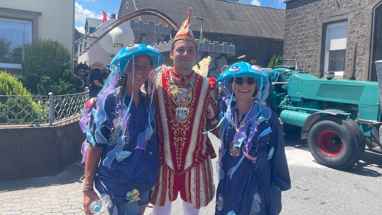 Prinz Henrik der Erste zwischen zwei Damen die lachend in die Kamera schauen