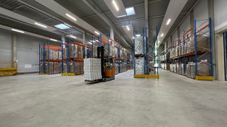 Ein Gabelstapler fährt durch mehrere Hochregale. In Andernach wurde am Montagvormittag das Landesmateriallager eröffnet.