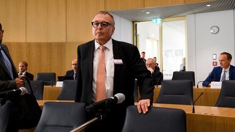 Der ehemalige Landrat des Kreises Ahrweiler Jürgen Pföhler steht in einem Raum an einem Stuhl. Gegen Pföhler wird vermutlich eine Disziplinaranklage wegen Versäumnissen bei der Flutkatastrophe im Ahrtal 2021 erhoben.