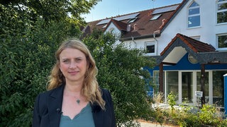 Nicole Falkenstein steht vor dem alten Gebäude der Lebenshilfe in Sinzig, in dem 12 Menschen ihr Leben verloren haben