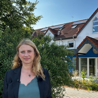 Nicole Falkenstein steht vor dem alten Gebäude der Lebenshilfe in Sinzig, in dem 12 Menschen ihr Leben verloren haben