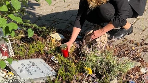 Nicole Falkenstein zündet eine Kerze für die zwölf Verstorbenen Bewohner in Sinzig an.