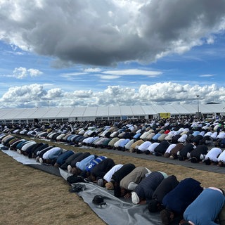 Zahlreiche muslimische Gläubige der Amadiyya-Glaubensgemeinschaft beten: Auf dem Flughafen in Mendig treffen sich zehntausende Gläubige zu ihrem Jahrestreffen