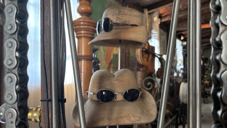 Hüte mit Sonnenbrillen in einem kinetischen Kunstwerk von Willi Reiche aus Remagen: Der sucht dringend nach einer neuen Ausstellungshalle. 