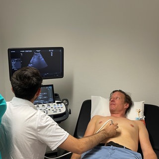Ärztin Nina Herbort zeigt David Winkler wie man eine Ultraschall-Untersuchung macht.