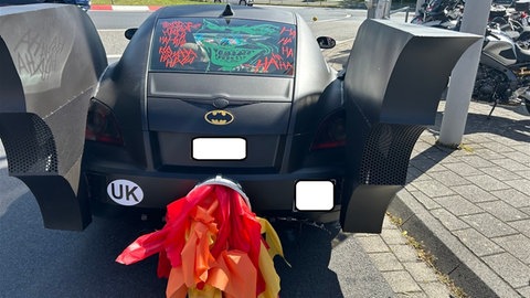Ein zum "Batmobil" umgebauter Chrysler mit Flügeln und simulierter Flamme aus dem Auspuff
