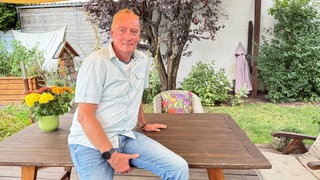 Stefan Linder sitzt in seinem Garten