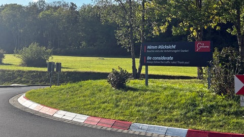 Ein Schild mit der Aufschrift "Nehmt Rücksicht - be considerate" am Nürburgring: Dort kritisieren Anwohner den Lärm durch Raser und Autoposer.