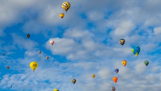Heißluftballons fliegen am Himmel (Symbolbild)