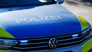 Aufschrift Polizei auf Polizeiauto mit Blaulicht
