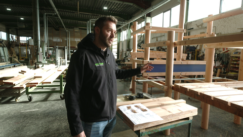Betriebsleiter Jonas Reutelsterz in der Produktionshalle vor einem Klettergerüst.